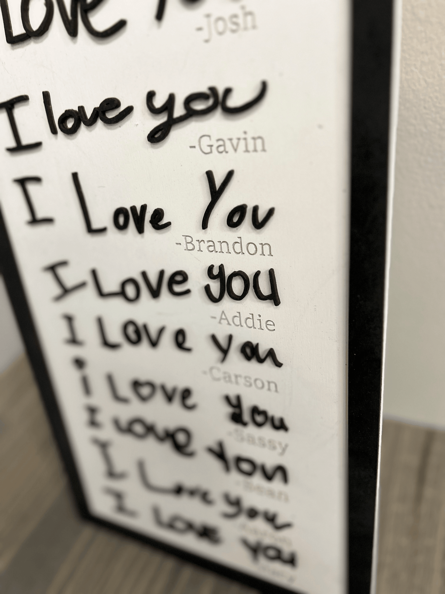 Handwritten signature in acrylic on a white background, featuring a fluid and stylized design