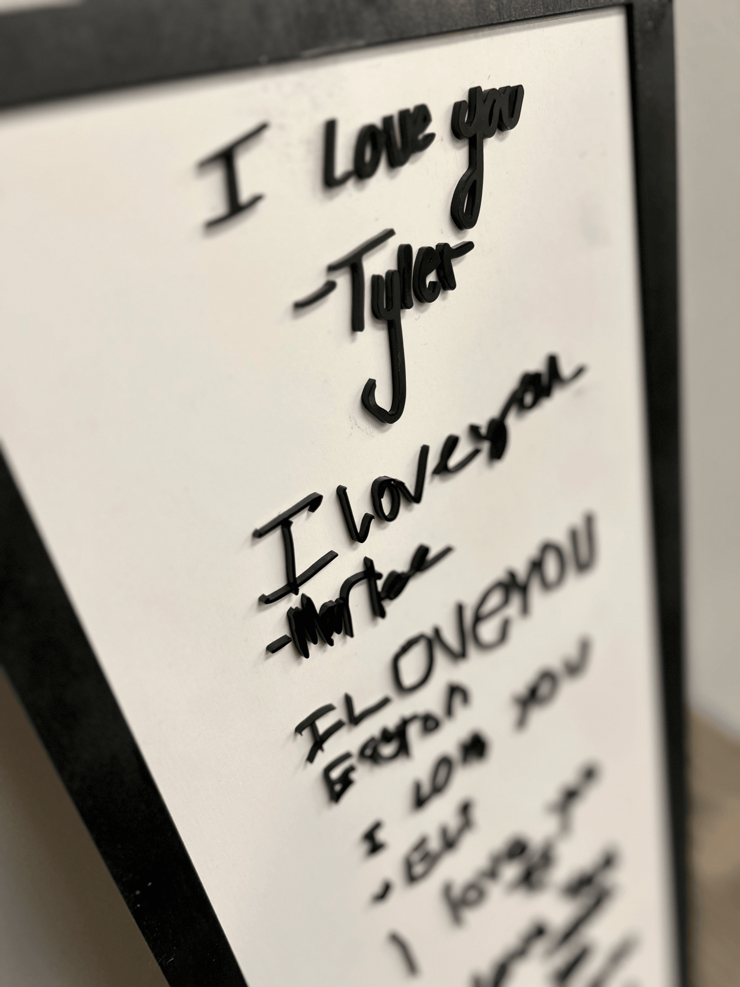 Elegant, free-flowing handwritten signature with connected cursive strokes in acrylic.