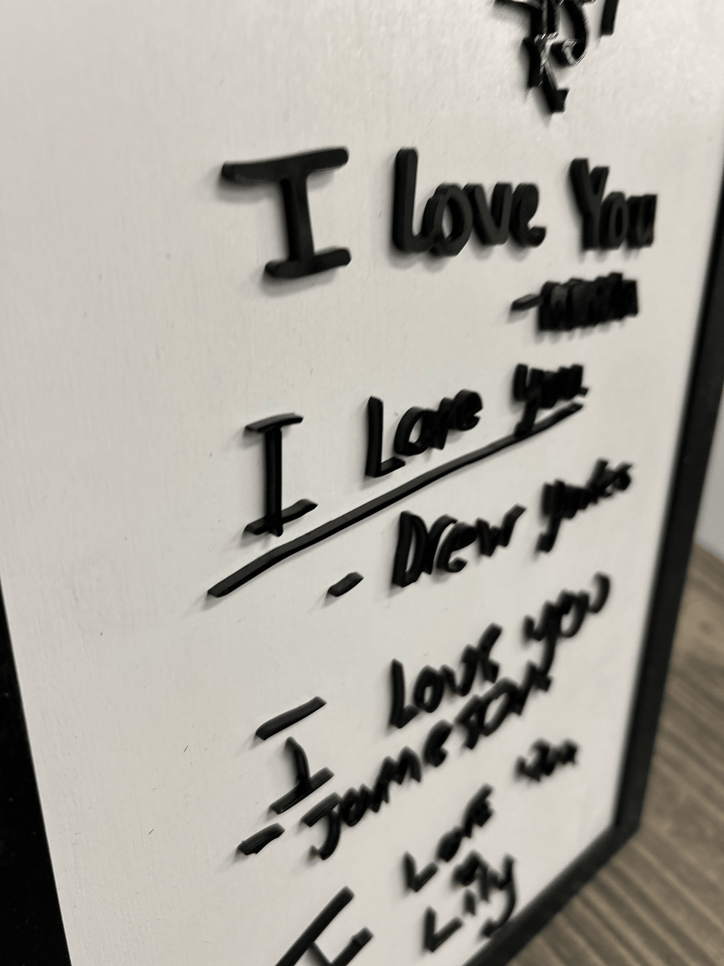 Distinct handwritten signature featuring a mix of sharp angles and rounded letters, made with acrylic.