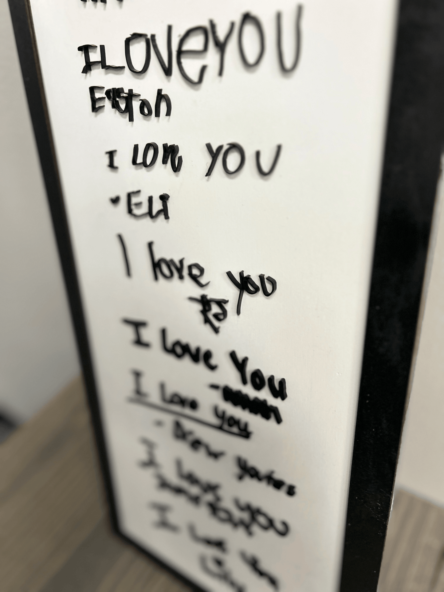 Distinct handwritten signature featuring a mix of sharp angles and rounded letters, made with acrylic
