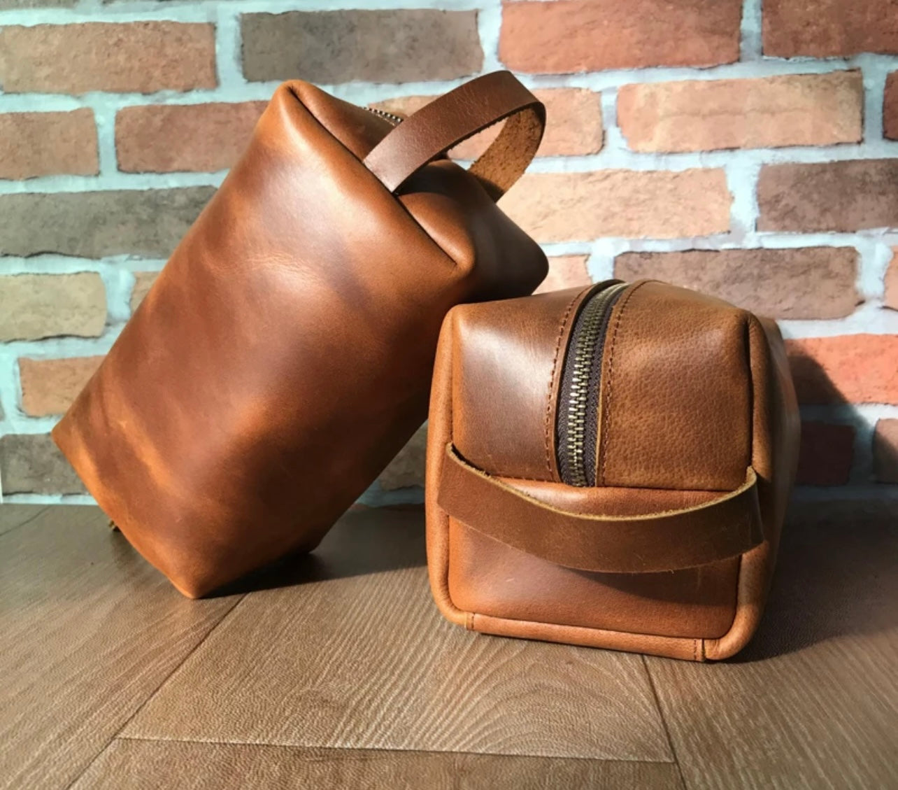 Brown leather Dopp kit with multiple compartments, designed for organizing toiletries and shaving accessories for men.
