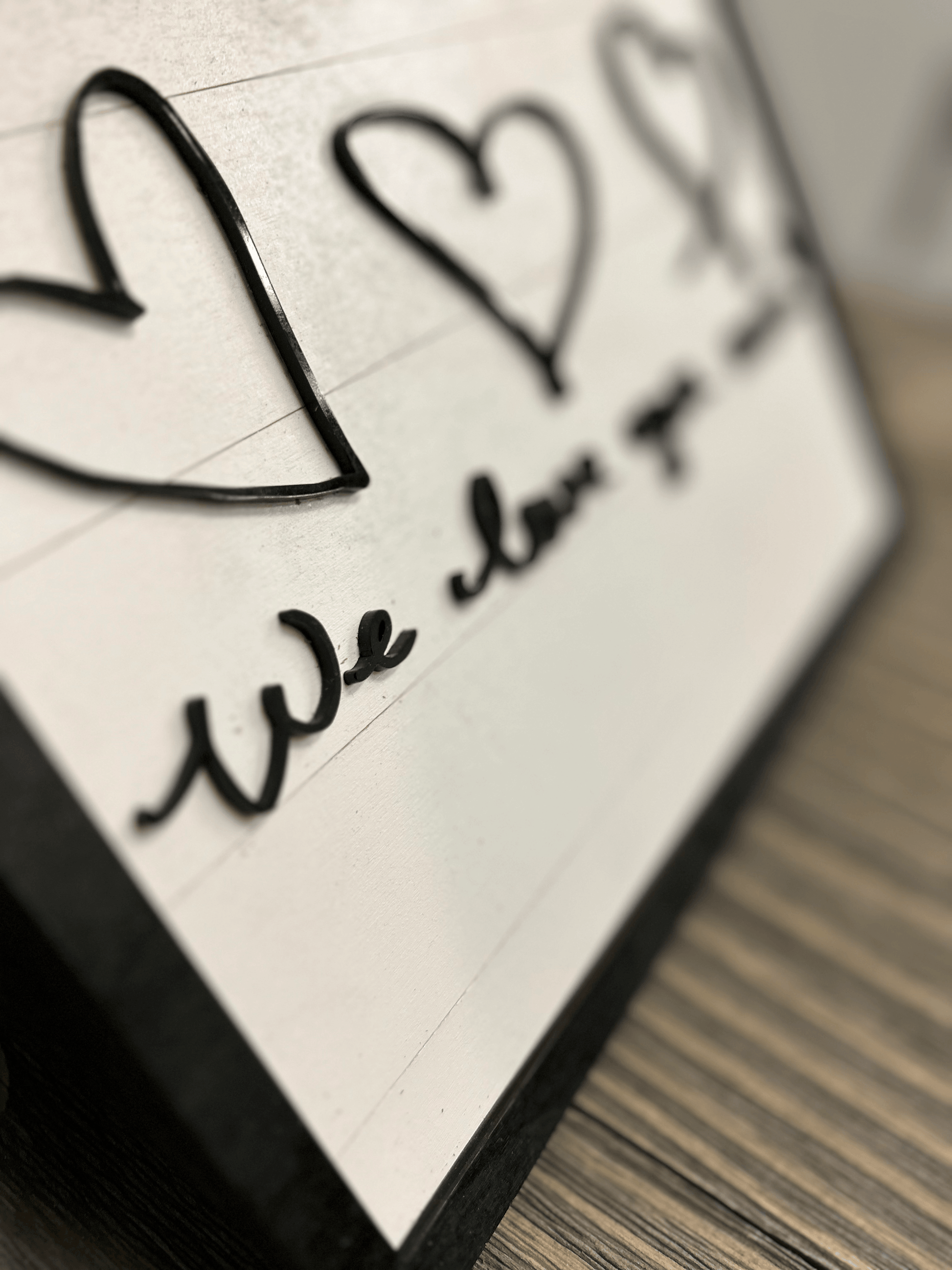 Hand-drawn signature with a sophisticated flourish, formed with acrylic on a light background