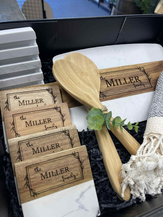 Set of wooden coasters and a spoon with 'Miller Family' engraving in a decorative box.