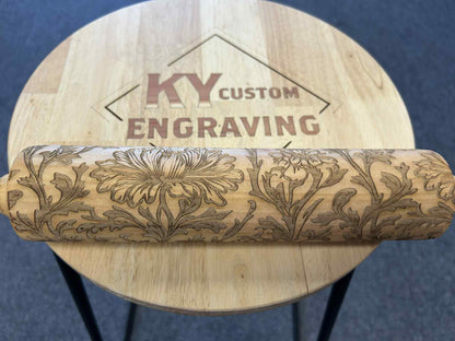 Laser engraved wooden rolling pin with floral pattern on custom engraving table