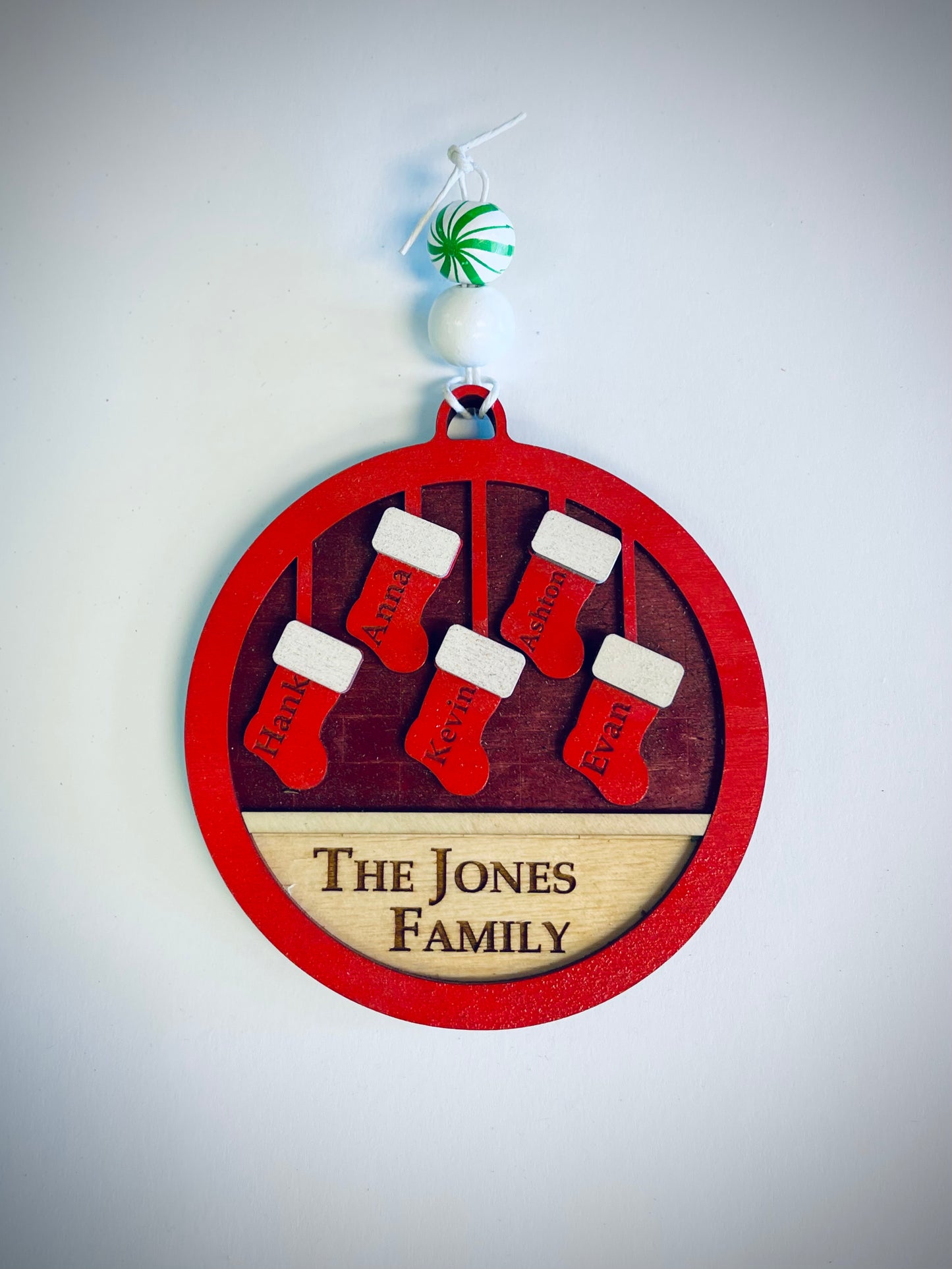 Personalized family Christmas ornament with red stockings and 'The Jones Family' text