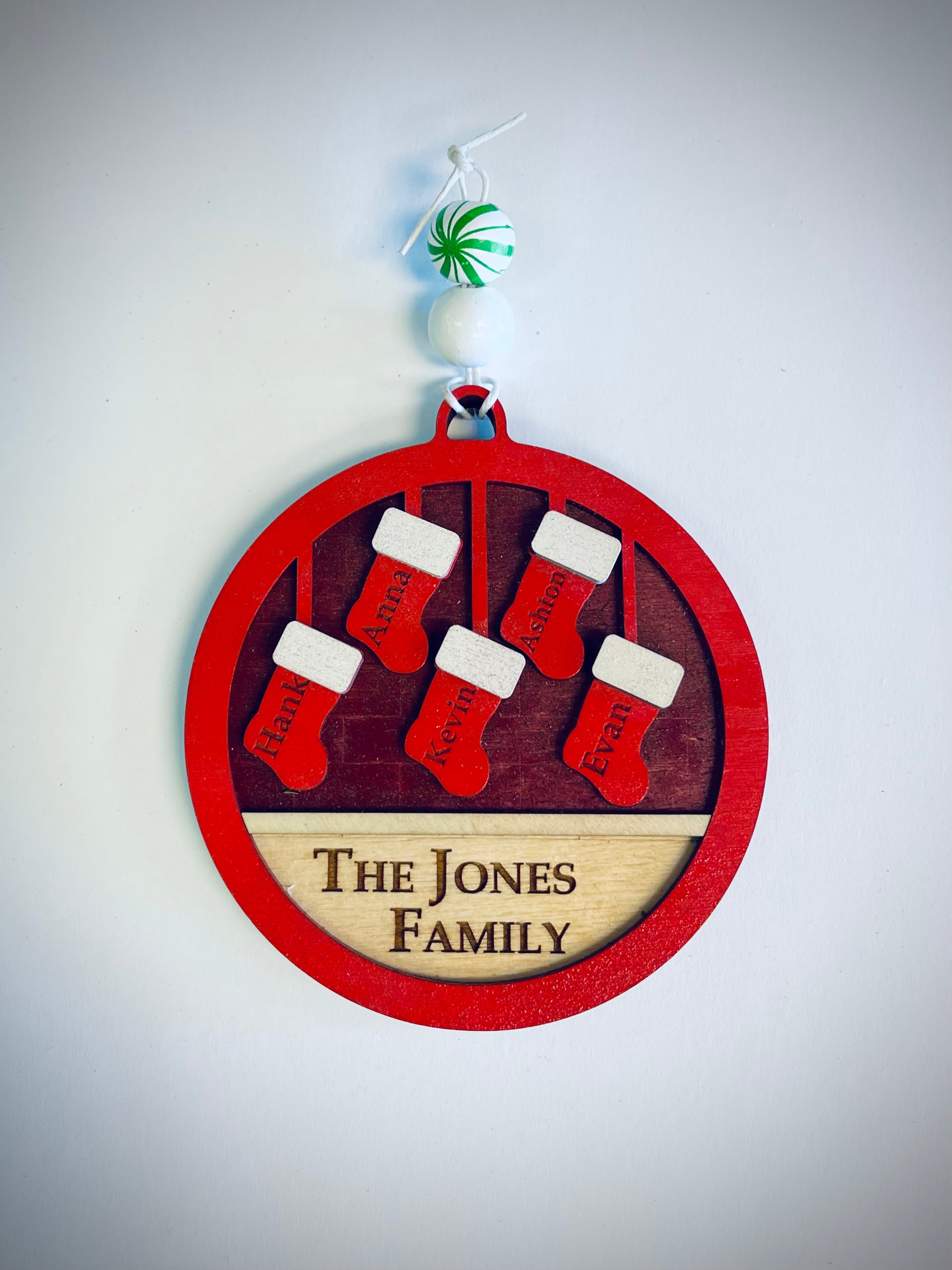 Personalized family Christmas ornament with red stockings and 'The Jones Family' text