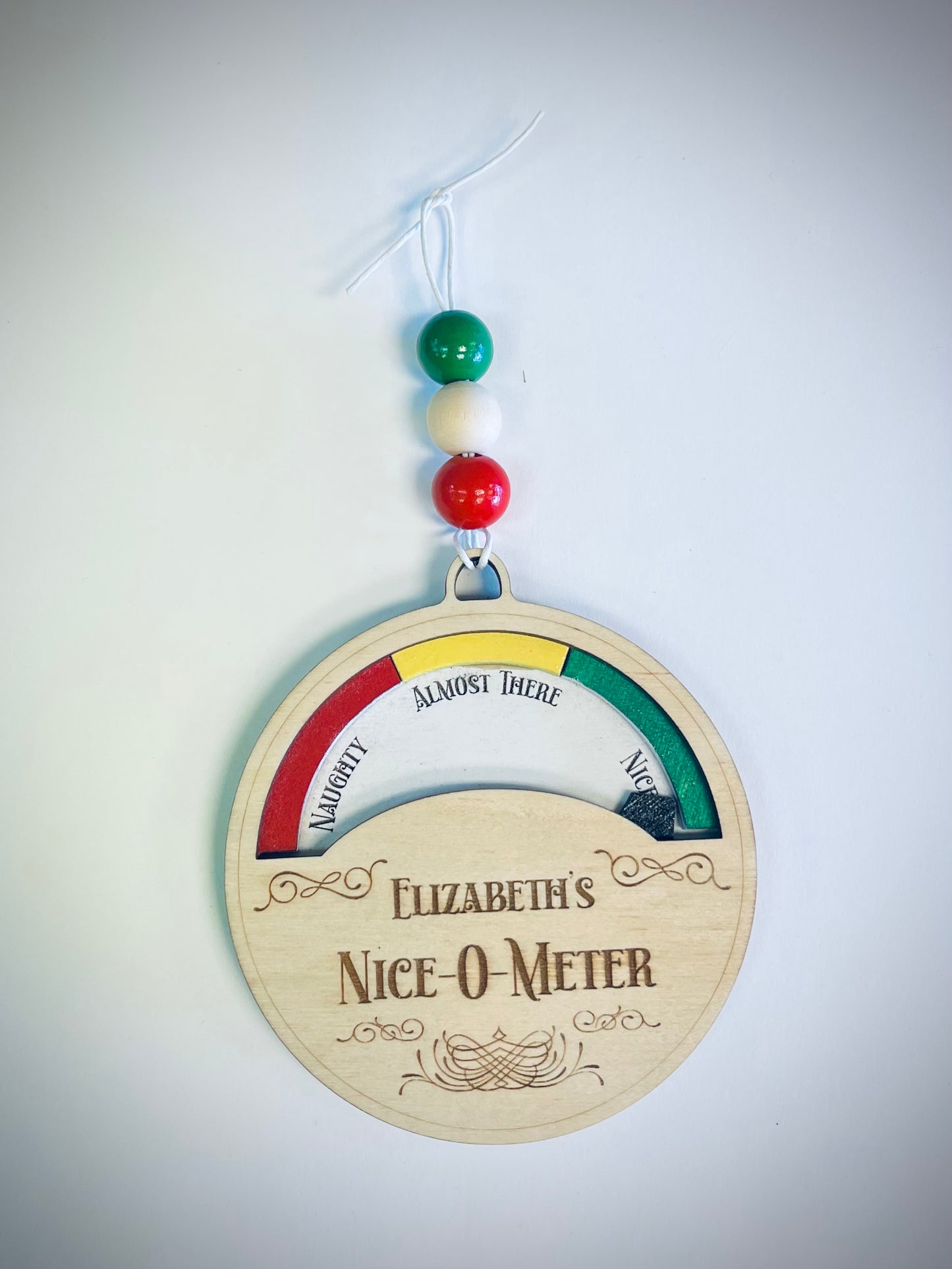 Wooden Nice-O-Meter ornament with colorful beads, labeled Naughty, Almost There, Nice.