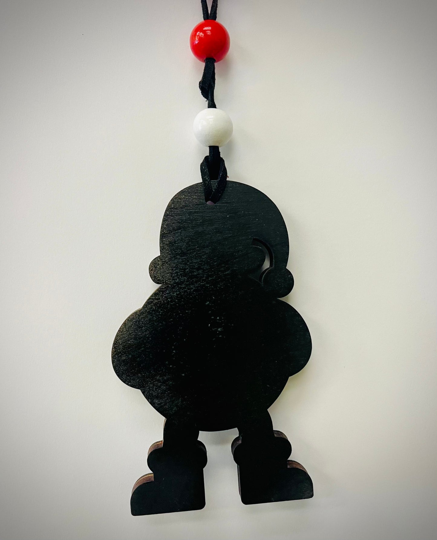 Black wooden Santa Cam ornament with red and white beads on a black cord, against a white background.