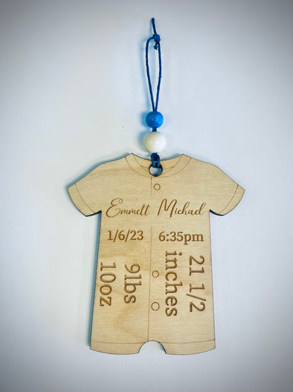 Wooden baby onesie ornament with engraved birth details and blue beads for decoration