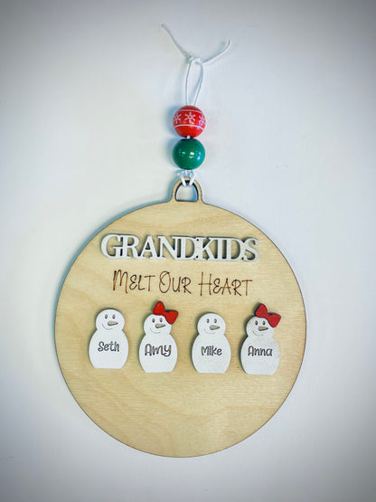 Wooden ornament with 'Grandkids Melt Our Heart' text and four snowmen with names, festive beads