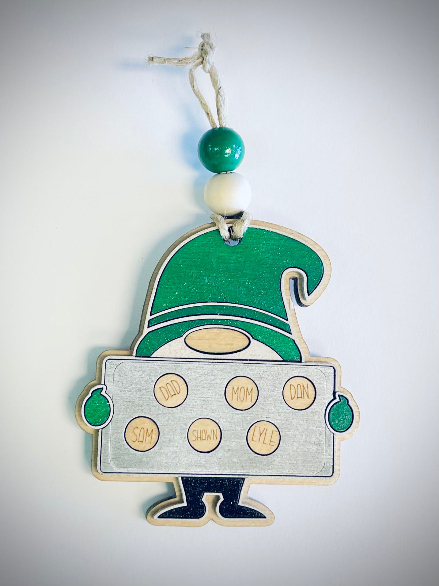 Wooden gnome ornament with green hat holding family cookie tray, personalized names visible