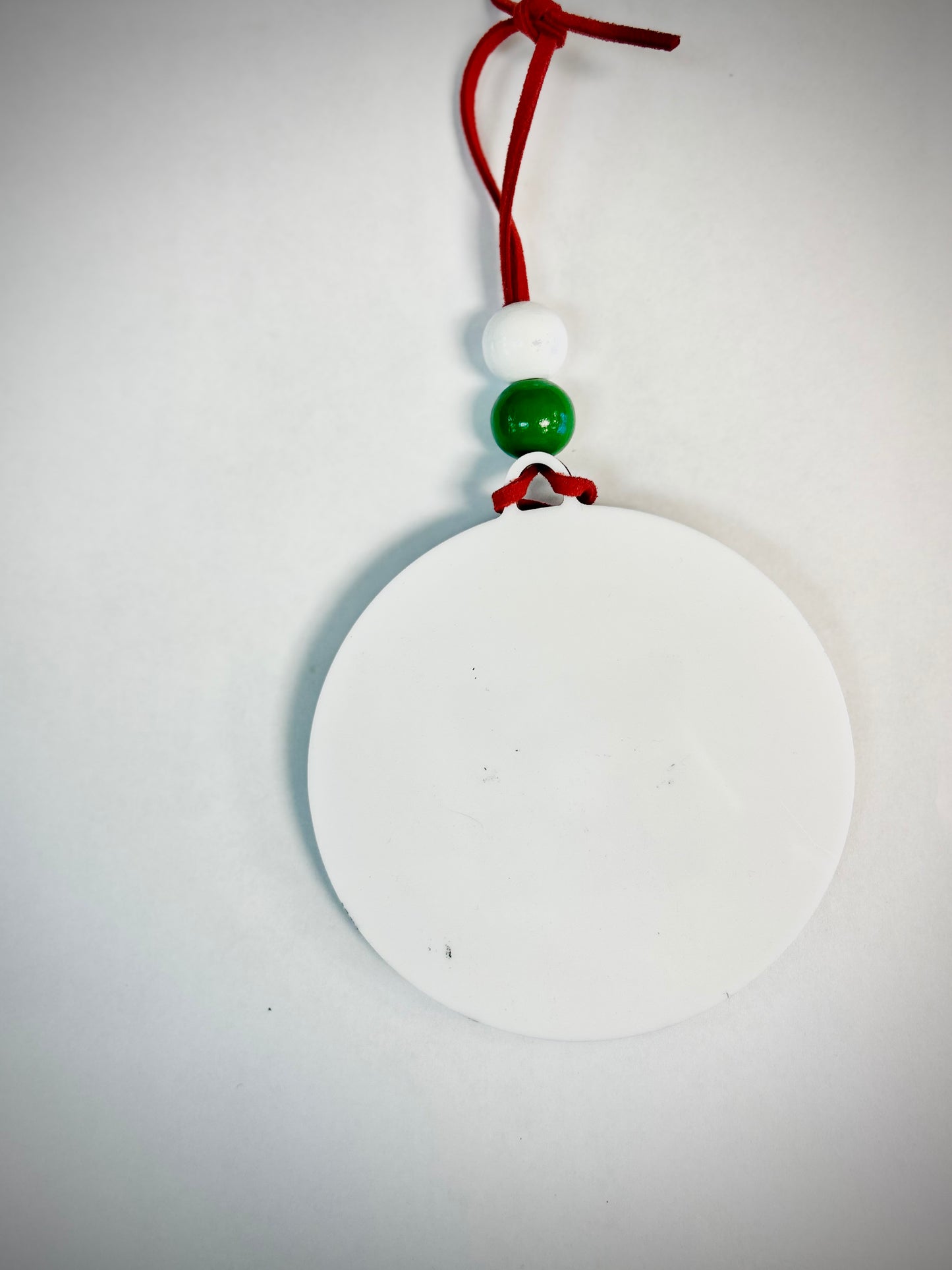 Blank round white Christmas ornament with red string and green and white beads