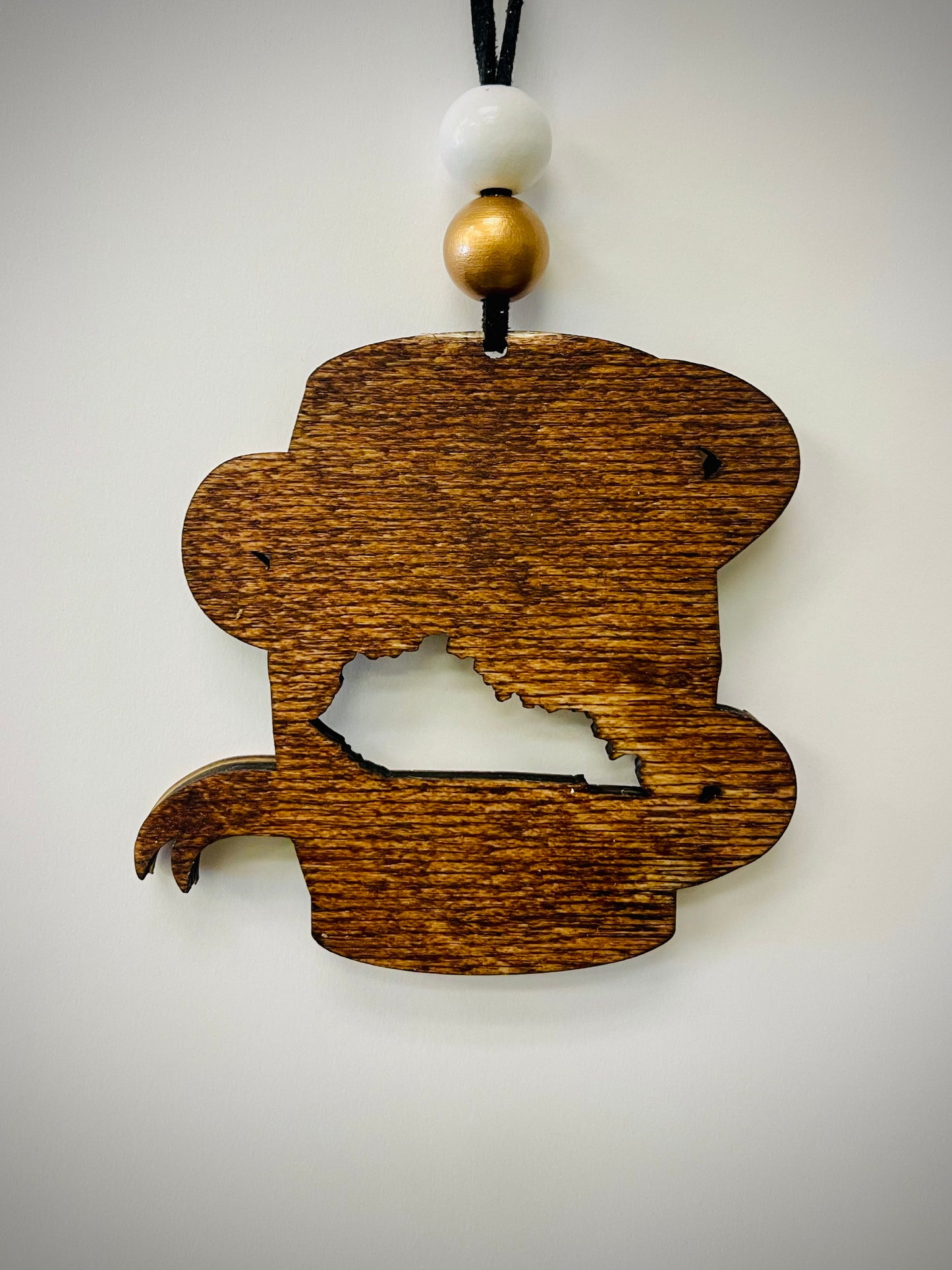 Wood bourbon barrel ornament with Kentucky cutout, white and gold beads, on white background