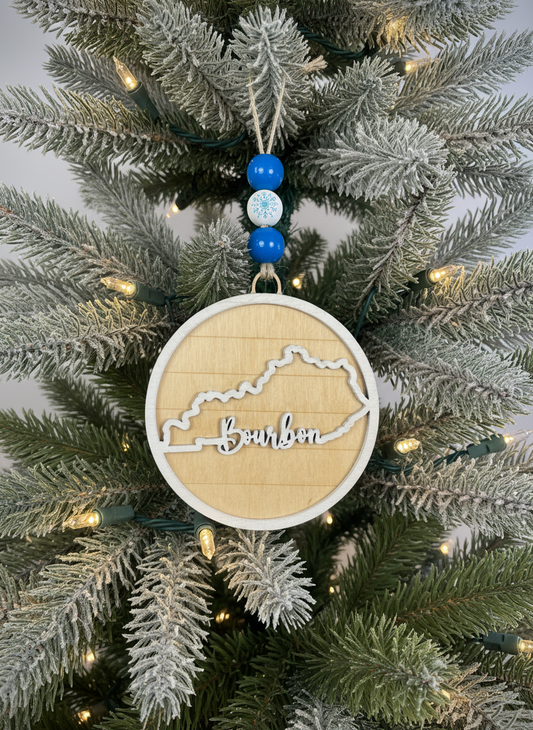 Bourbon Kentucky wooden ornament with state outline on a Christmas tree with lights
