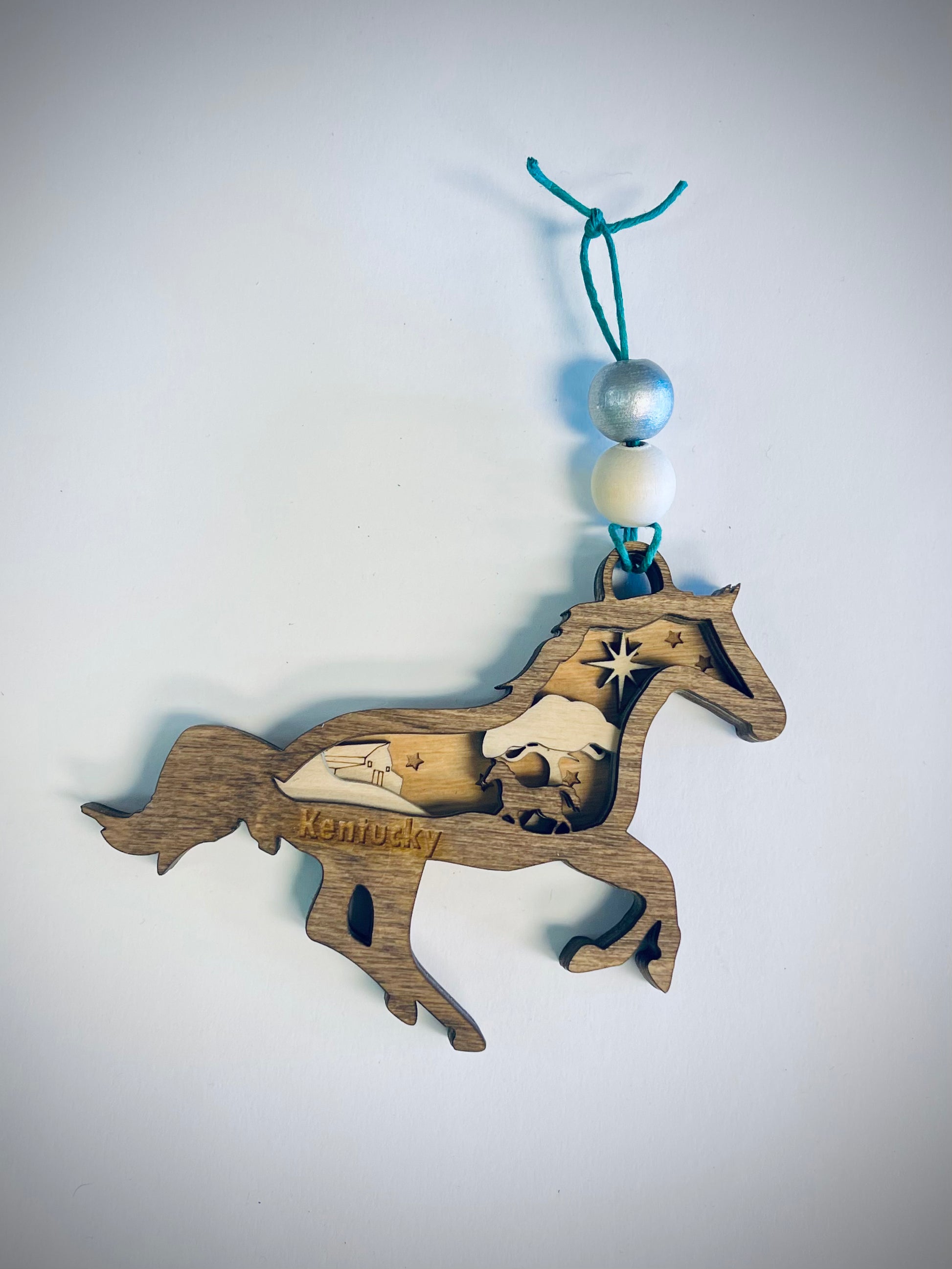 Layered wooden horse ornament with Kentucky engraving and blue string, rustic decor