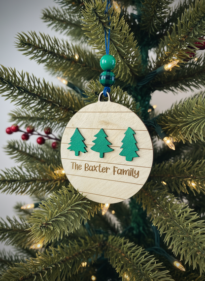 Personalized wood ornament with three green trees and The Baxter Family text on Christmas tree
