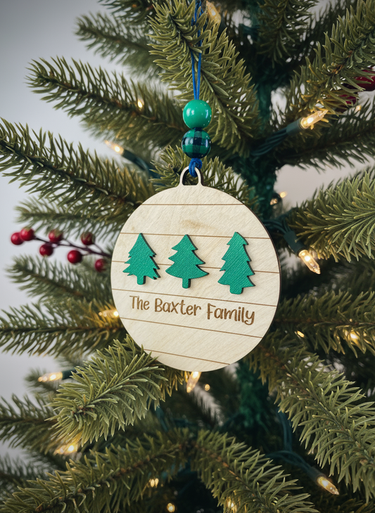 Personalized wood ornament with three green trees and The Baxter Family text on Christmas tree