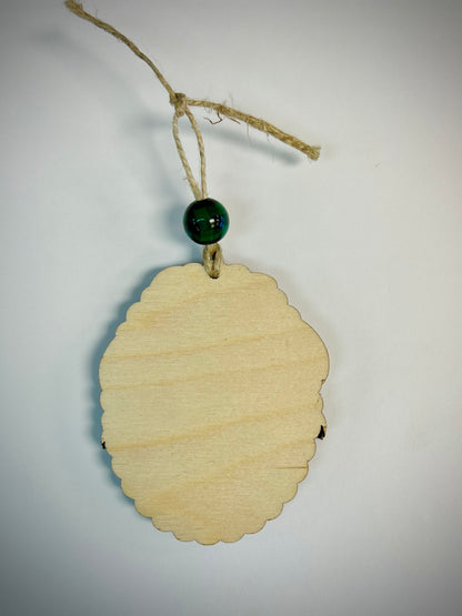 Blank oval wood Christmas ornament with scalloped edges, twine, and green bead