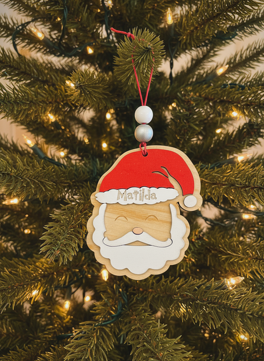 Personalized Santa wood ornament named Matilda on Christmas tree with lights