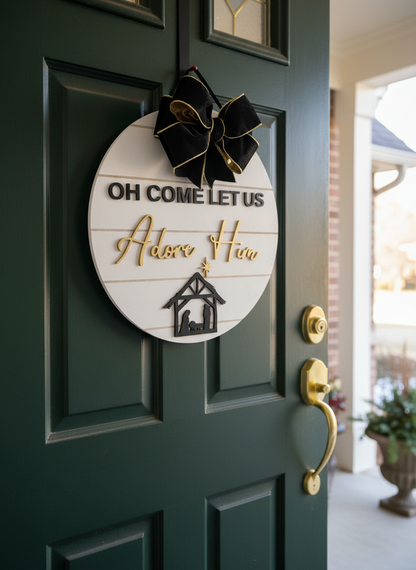 Christmas door hanger with 'Oh Come Let Us Adore Him' and nativity on green door