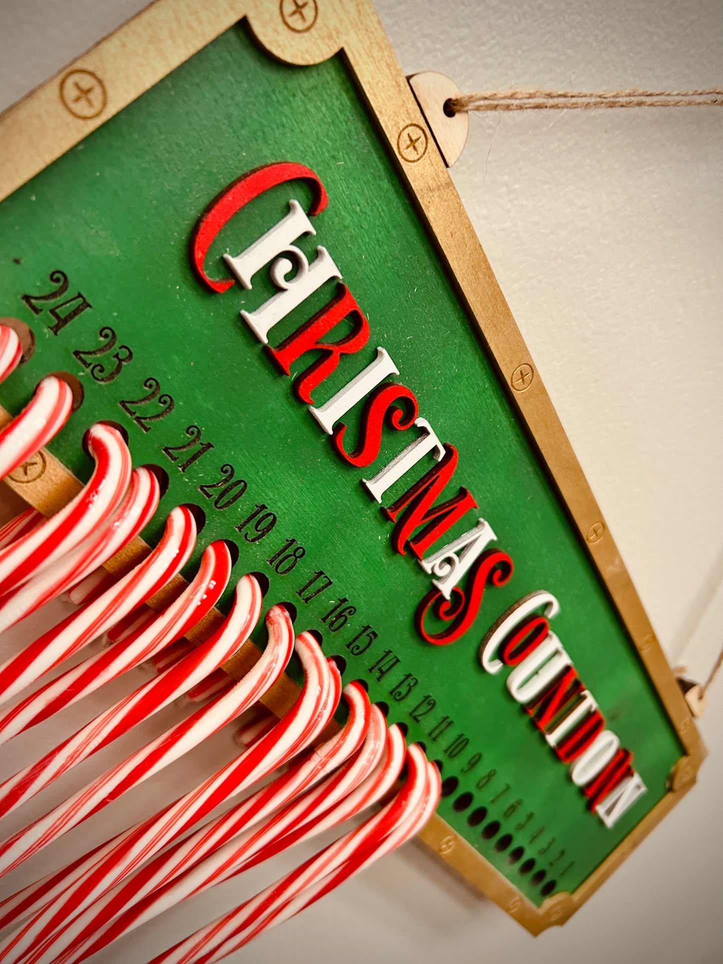Christmas countdown sign with candy canes on hooks, green and gold festive decor