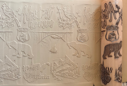 Custom laser-engraved West Virginia designs featuring bears, birds, and scenic landscapes on wood.